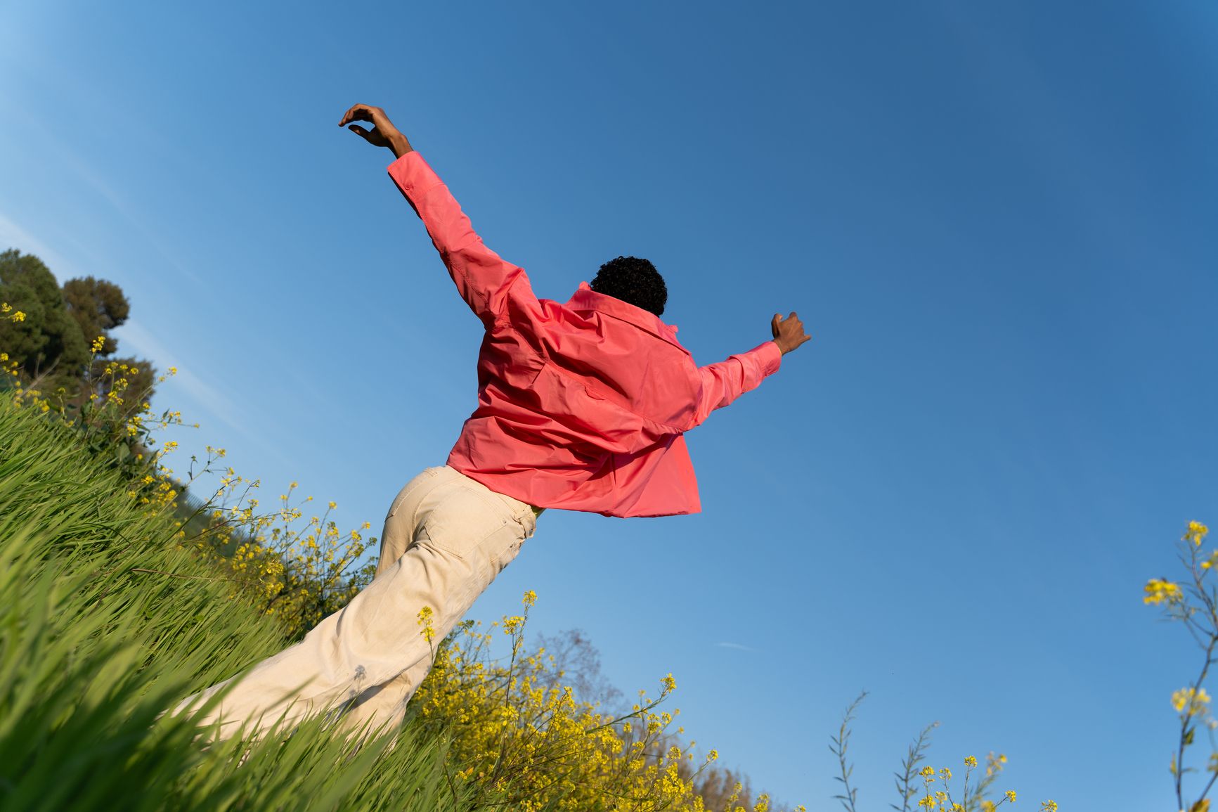 Someone leaping through a field of yellow flowers
