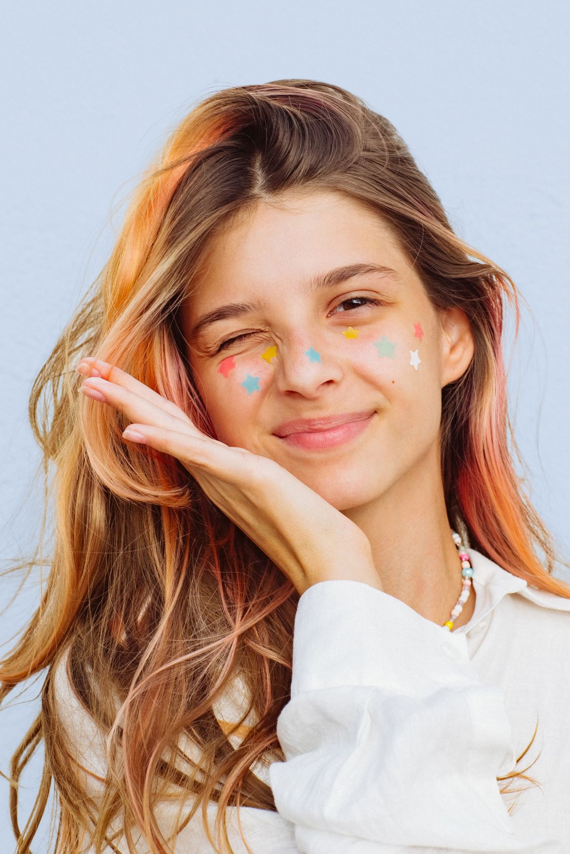 Smiling girl with colorful patches, winking